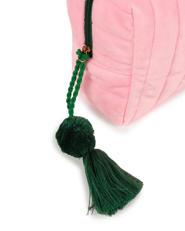Green tassel hanging from a pink bag on a white background