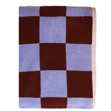 Checkered blanket with brown and light blue squares on a white background