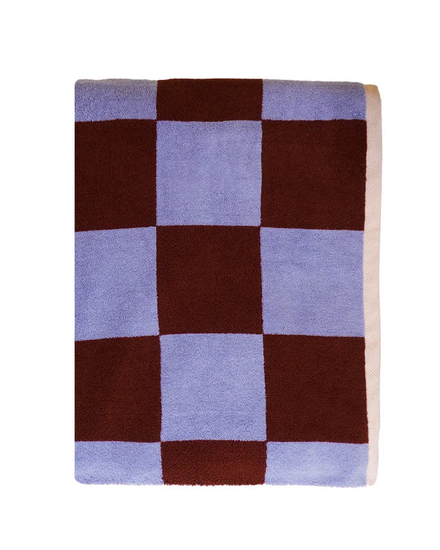 Checkered blanket with brown and light blue squares on a white background