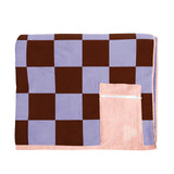 Checkered blanket with a pink pouch on a white background
