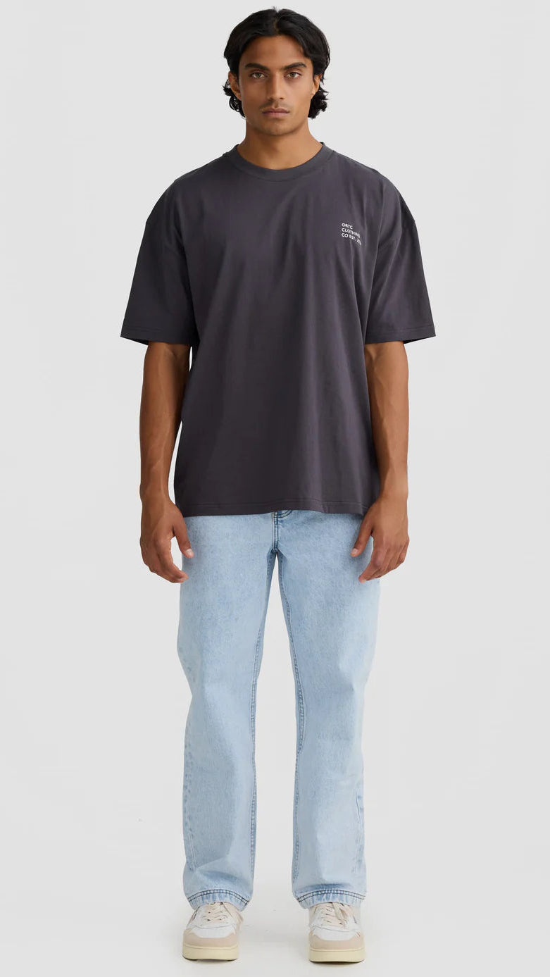 Person wearing a dark gray t-shirt and light blue jeans on a white background