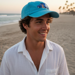 Man wearing a blue cap and white shirt on a beach