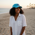 Woman wearing a blue cap and white shirt on a beach