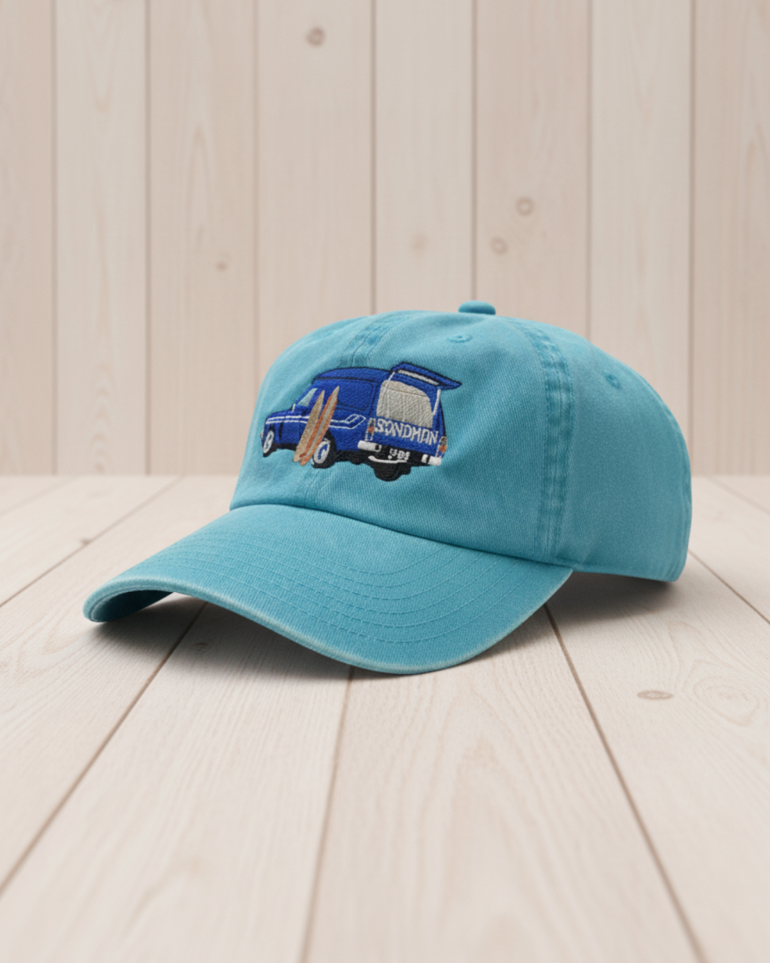 Blue cap with embroidered design on a light wooden surface