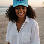 Woman wearing a blue cap and white shirt on a beach