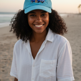 Woman wearing a blue cap and white shirt on a beach