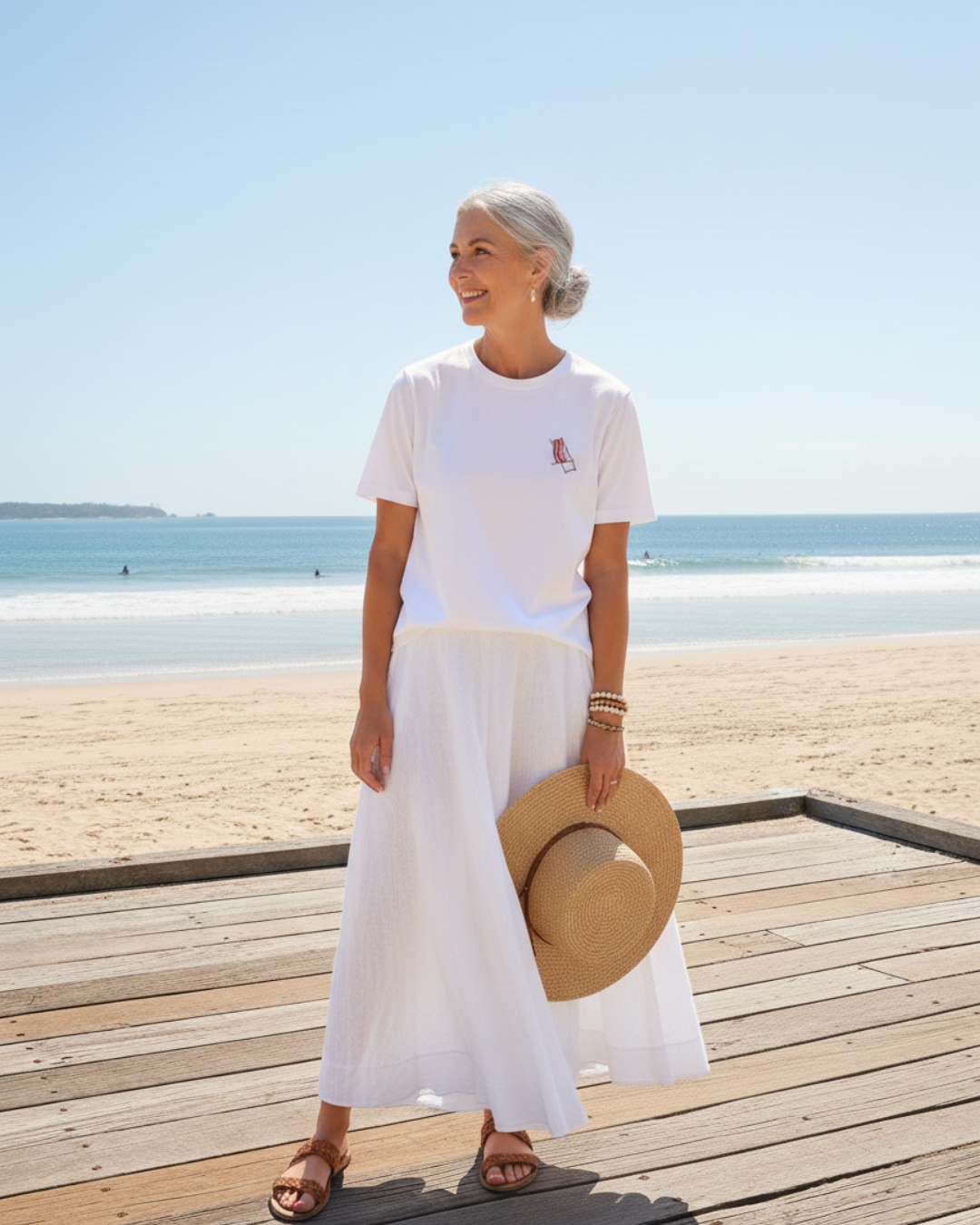 Woman in white outfit with a straw hat on a beach