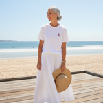 Woman in white outfit with a straw hat on a beach