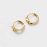 Gold hoop earrings on a light gray background