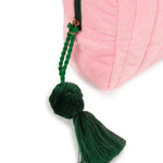 Green tassel hanging from a pink bag on a white background