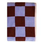 Checkered blanket with brown and light blue squares on a white background