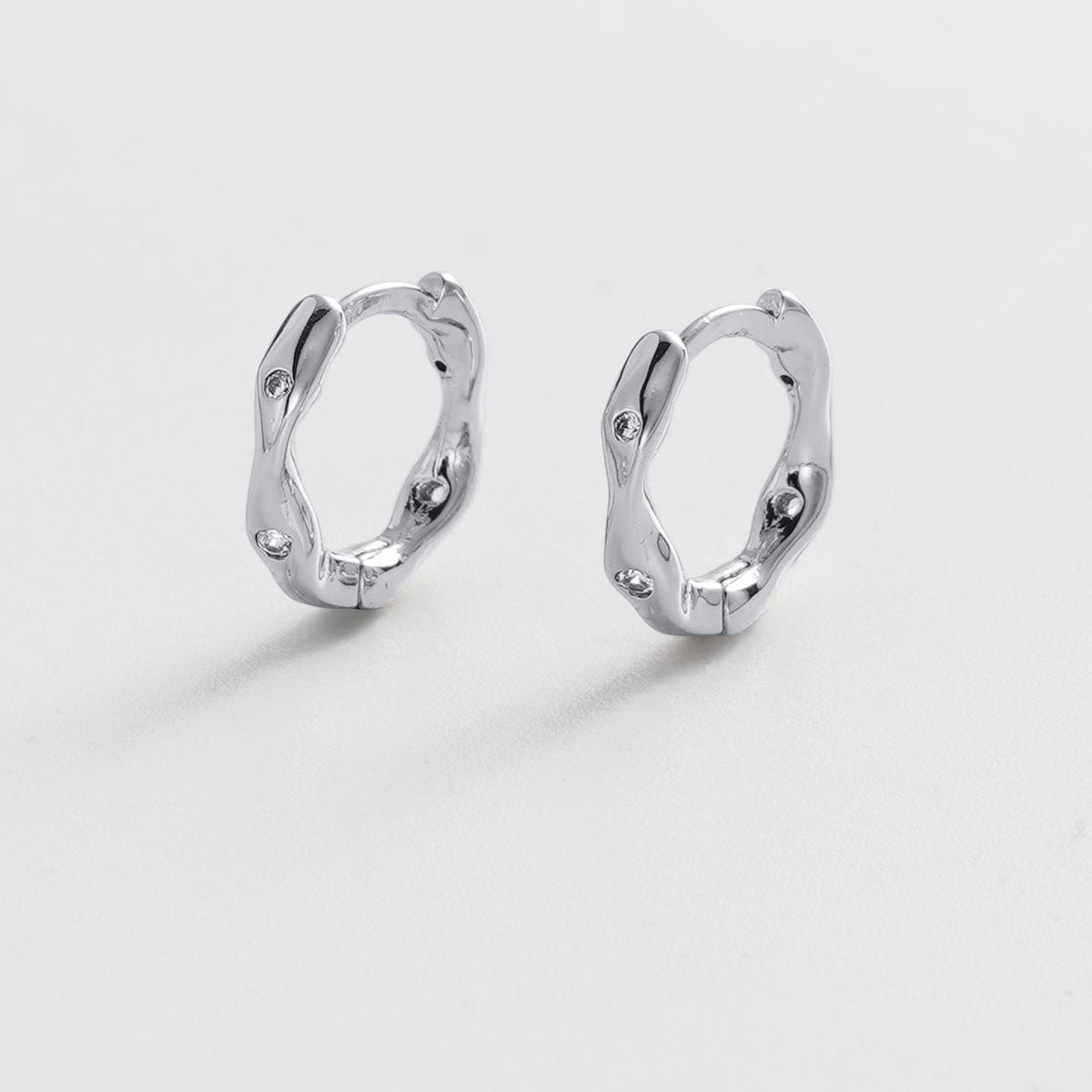 Pair of silver hoop earrings on a light gray background