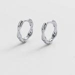 Pair of silver hoop earrings on a light gray background