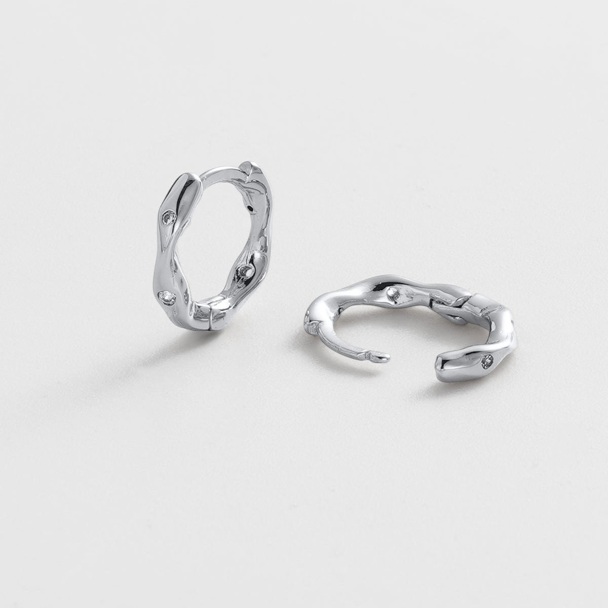 Pair of silver hoop earrings on a light gray background
