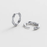 Pair of silver hoop earrings on a light gray background