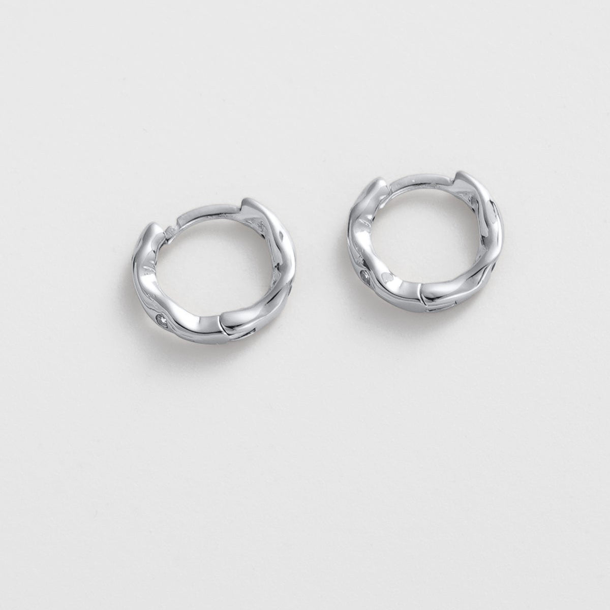 Pair of silver hoop earrings on a light gray background