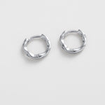 Pair of silver hoop earrings on a light gray background