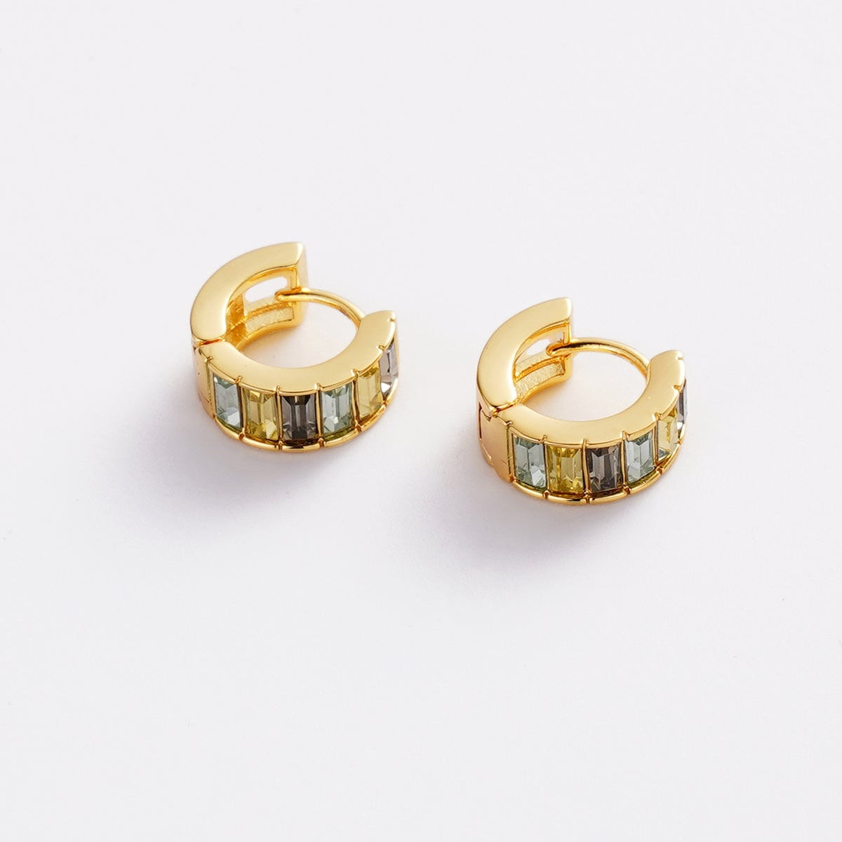 A pair of gold huggie hoop earrings with rectangular iridescent stones, displayed on a clean white background.