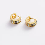 A pair of gold huggie hoop earrings with rectangular iridescent stones, displayed on a clean white background.