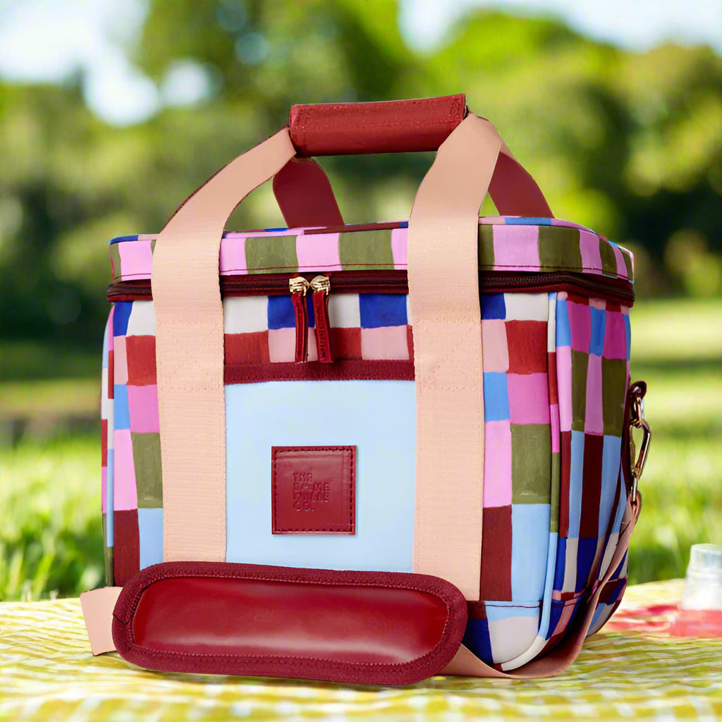 Colorful checkered bag with a red handle on a white background