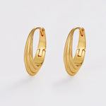 Gold hoop earrings on a light gray background