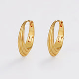 Gold hoop earrings on a light gray background