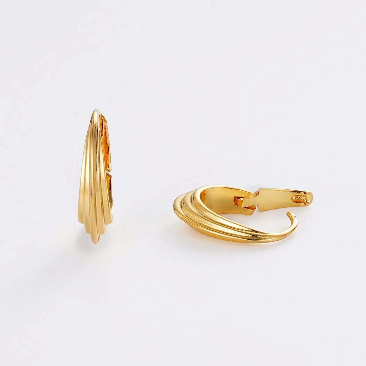 Gold hoop earrings on a light gray background