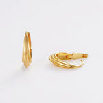 Gold hoop earrings on a light gray background