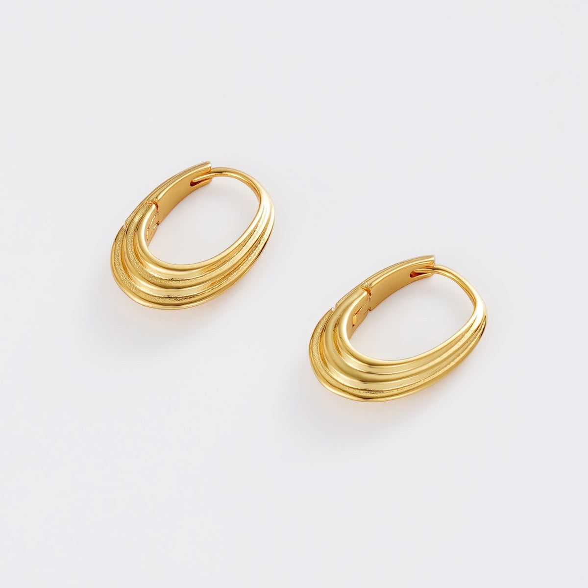 Pair of gold hoop earrings on a light gray background