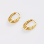 Pair of gold hoop earrings on a light gray background