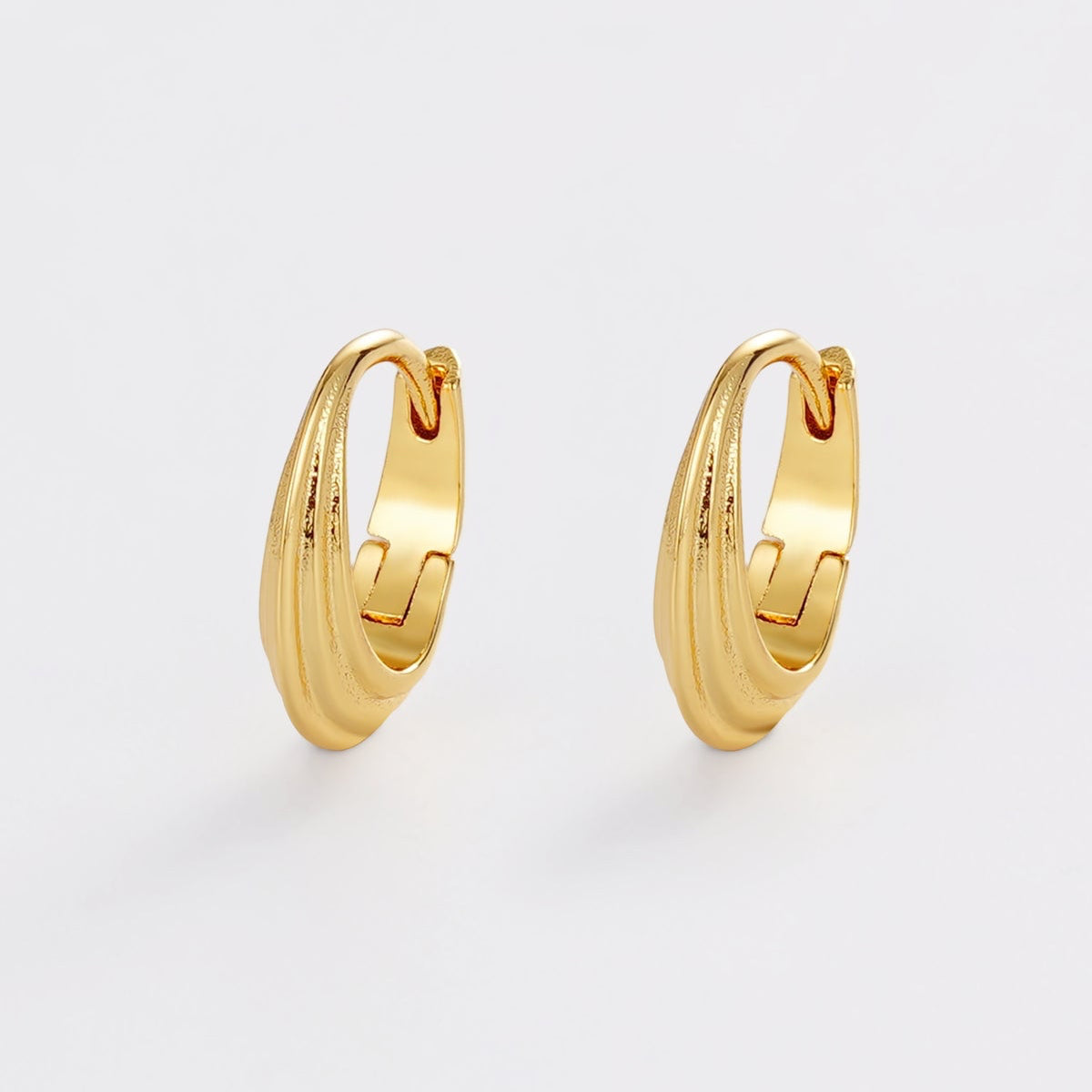 Gold hoop earrings on a light gray background