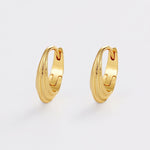 Gold hoop earrings on a light gray background