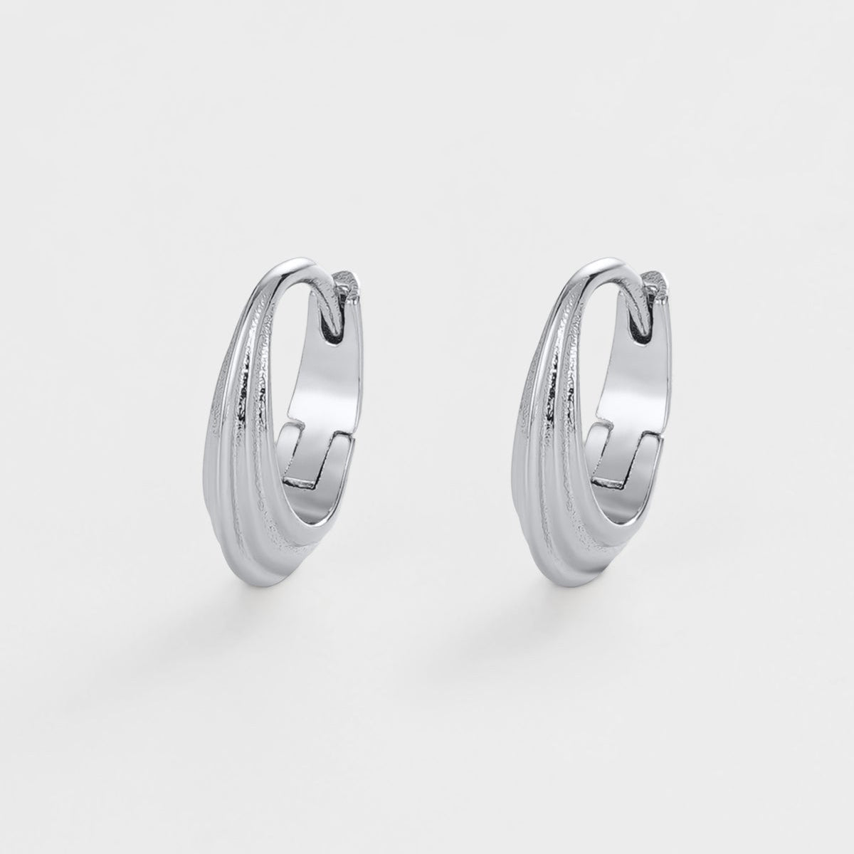 Pair of silver hoop earrings on a light gray background