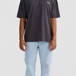 Person wearing a dark gray t-shirt and light blue jeans on a white background