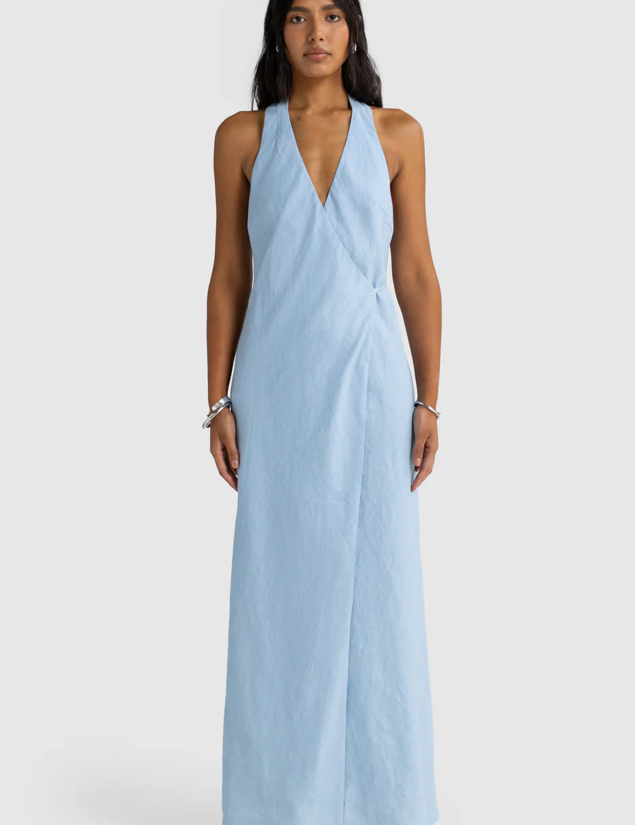 Woman wearing a light blue halter neck dress on a white background