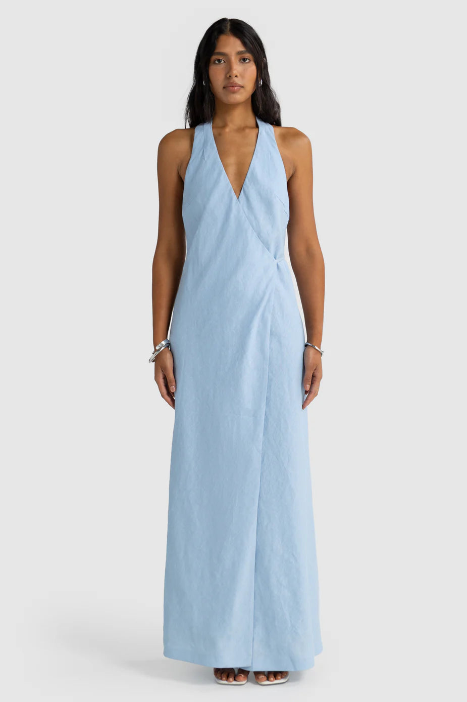 Woman wearing a light blue halter neck dress on a white background