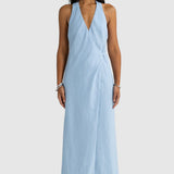 Woman wearing a light blue halter neck dress on a white background
