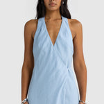 Woman wearing a light blue dress against a white background