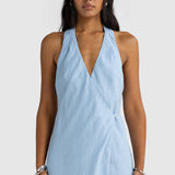 Woman wearing a light blue dress against a white background