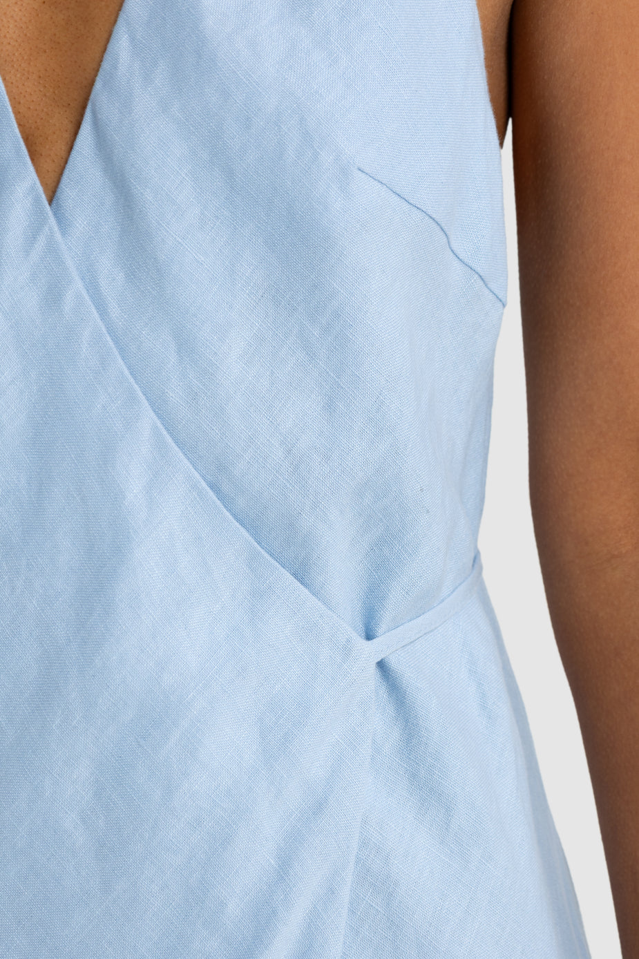 Light blue sleeveless top with a V-neckline on a neutral background