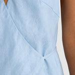 Light blue sleeveless top with a V-neckline on a neutral background