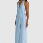 Woman wearing a light blue jumpsuit on a white background