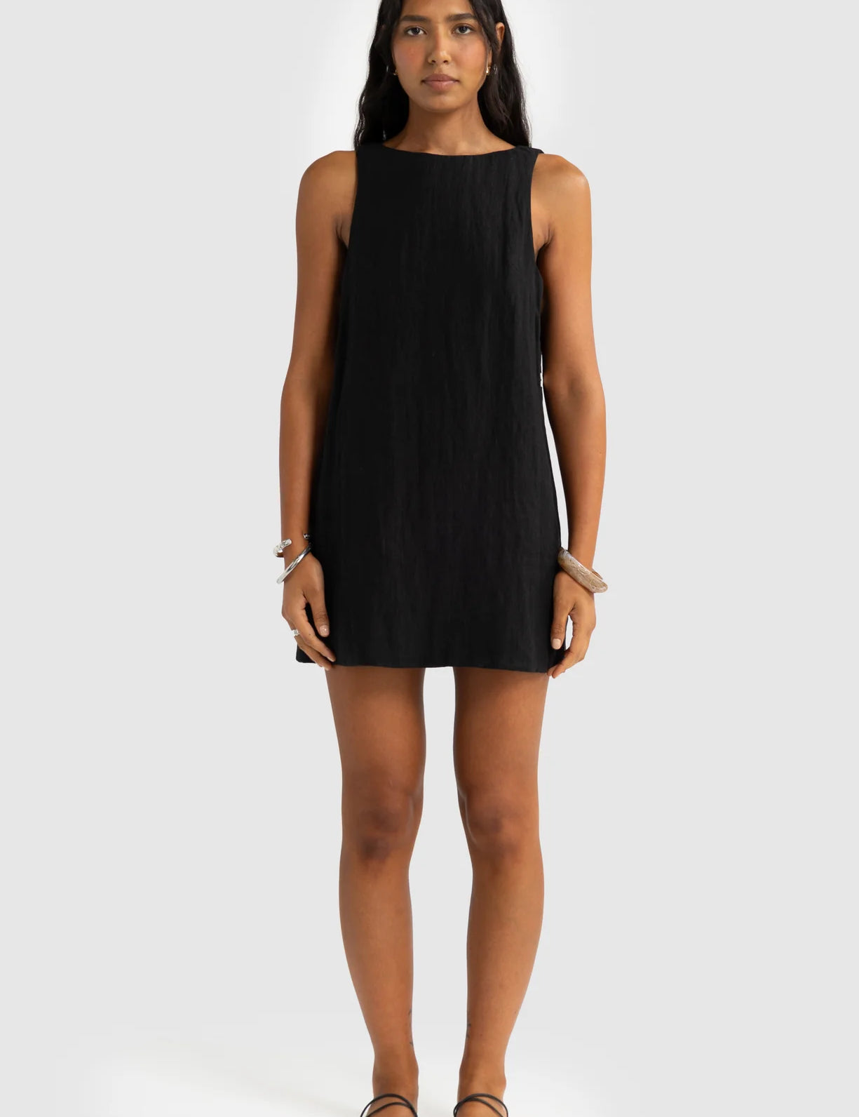 Woman wearing a black sleeveless dress on a white background