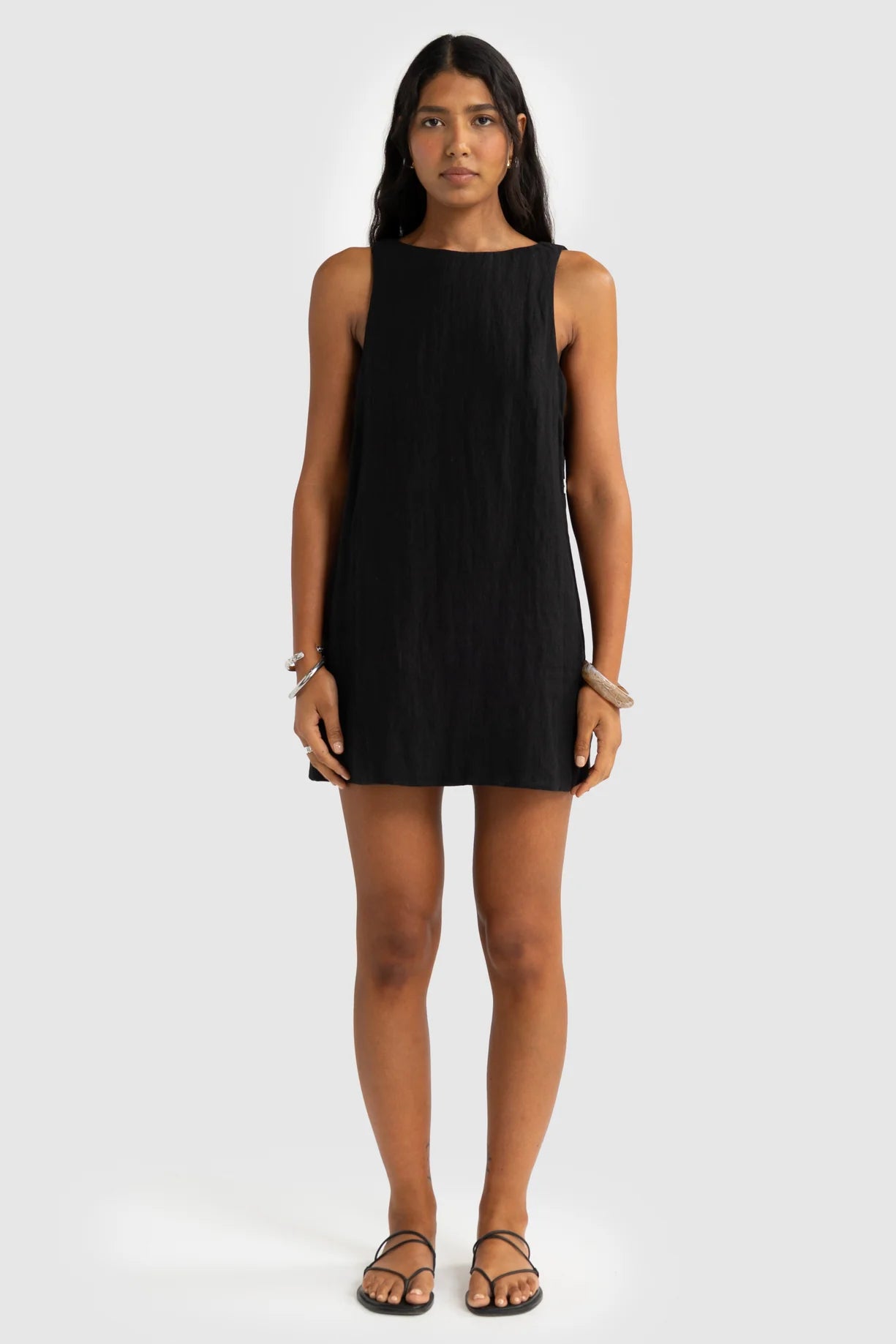 Woman wearing a black sleeveless dress on a white background