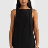 Woman wearing a black sleeveless dress against a white background