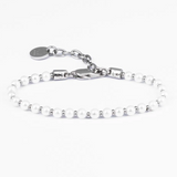 Silver bracelet with small pearls on a white background