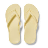 Pair of light yellow flip-flops on a white background