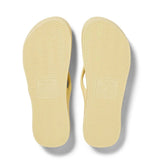 Pair of yellow flip-flops on a white background