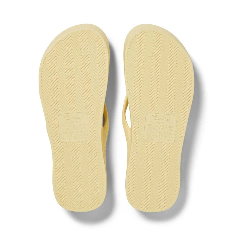 Pair of yellow flip-flops on a white background