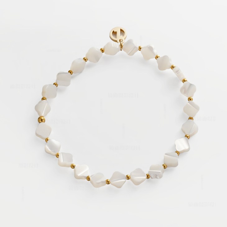 A delicate beaded bracelet made of irregular white mother-of-pearl beads separated by small gold spacer beads, with a gold clasp featuring a circular logo, displayed on a clean white background.